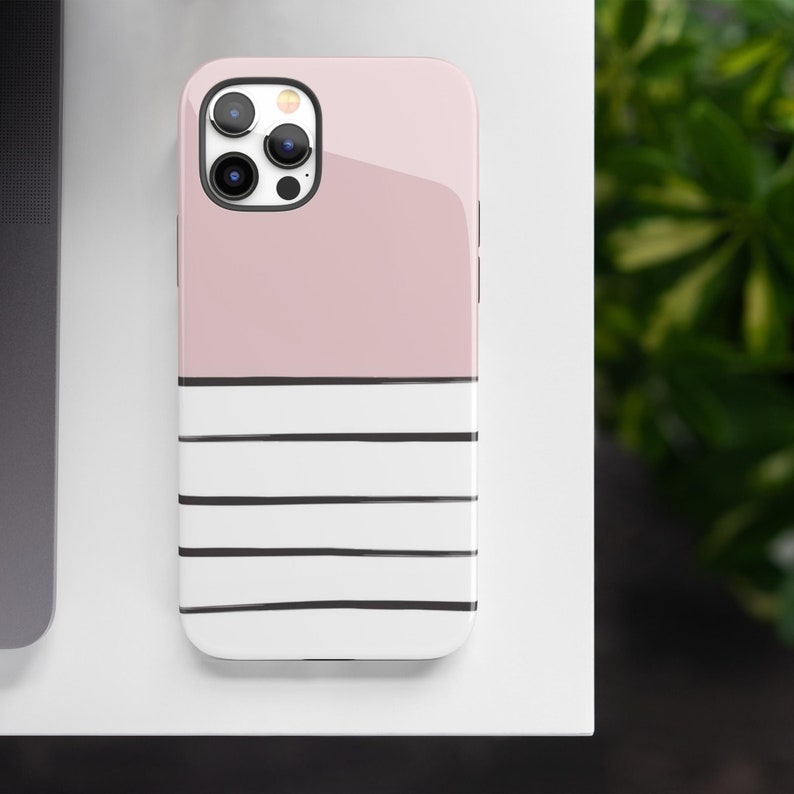 May include: A pink and white striped phone case with a black camera lens cutout.