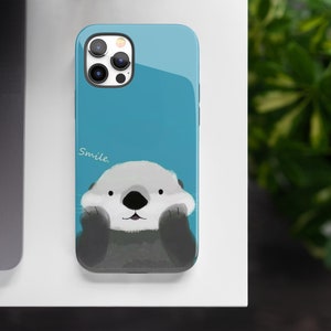 May include: A blue phone case with a cartoon sea otter wearing a smile and the word "Smile." printed on the case.