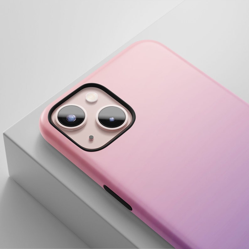May include: A pink and purple gradient phone case with a black camera cutout and two black camera lenses.