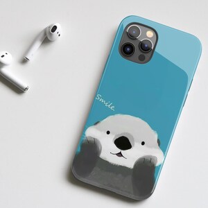 May include: A blue phone case with a cartoon sea otter and the word "Smile." printed on it.