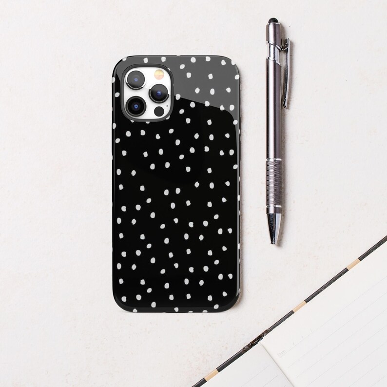 May include: Black phone case with a white polka dot pattern.