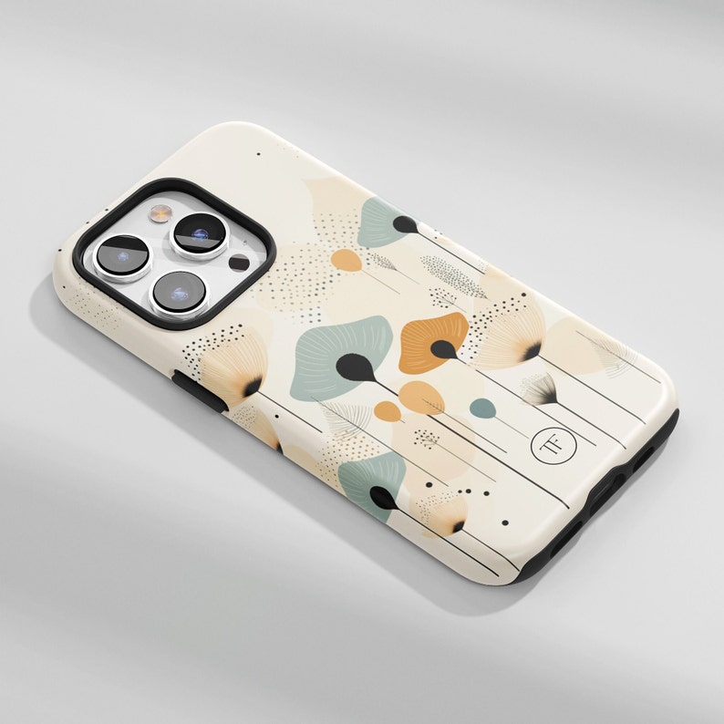 K&ouml;nnte beinhalten: Eine wei&szlig;e iPhone-H&uuml;lle mit einem Blumendesign mit abstrakten Blumen in Beige-, Orange- und Blaut&ouml;nen. Die H&uuml;lle hat einen schwarzen Rand und einen kleinen schwarzen Kreis mit den Buchstaben "TF" in Wei&szlig;.