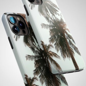 May include: A white phone case with a tropical palm tree design. The case features a light blue background with brown palm trees.