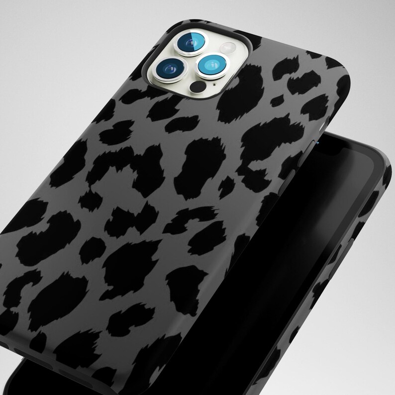 May include: A smartphone case with a gray leopard print design. The case is black and gray with a glossy finish. The phone case is shown with a black smartphone.