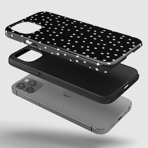 May include: A black phone case with a white polka dot pattern. The case is shown in three pieces, with the phone itself in the bottom layer.
