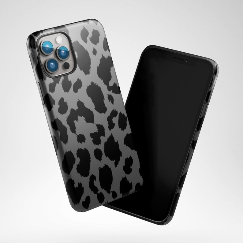 May include: Two smartphones, one with a black screen and the other with a gray leopard print case. The case has black spots on a gray background. The phones are positioned at an angle, suggesting a modern design.
