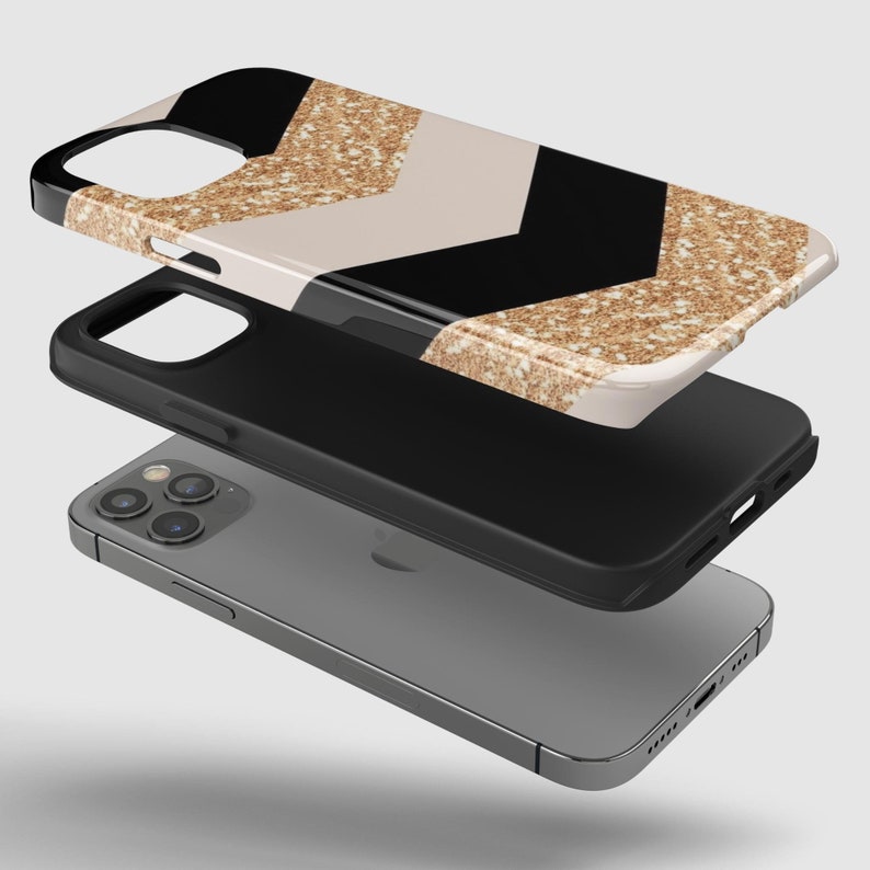 Puede incluir: Una funda para tel&eacute;fono de patr&oacute;n de chevron blanco y negro con detalles de purpurina dorada. La funda est&aacute; dise&ntilde;ada para adaptarse a un iPhone.