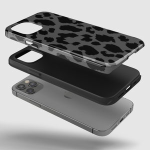 May include: A layered phone case with a gray leopard print design. The case is shown in three separate pieces, with the phone visible at the bottom. The top layer has a glossy finish, while the middle layer is black.