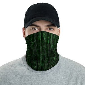 May include: A black face mask with a green digital code pattern. The mask is being worn by a person with a black baseball cap.