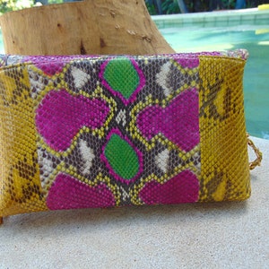 May include: A yellow, pink, green and black snakeskin clutch with a tassel.