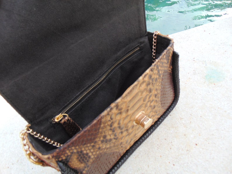 Peut inclure: Un petit sac &agrave; main en peau de serpent marron avec une doublure en tissu noir et une bandouli&egrave;re en cha&icirc;ne dor&eacute;e.
