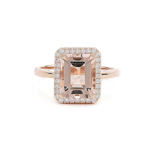 Puede incluir: Un anillo de oro rosa con una gran morganita rectangular de color rosa claro rodeada por un halo de diamantes más pequeños.