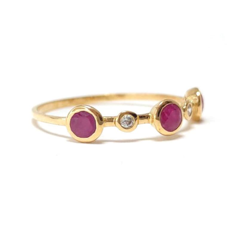 Puede incluir: Un anillo de oro con cinco piedras redondas. Las piedras est&aacute;n engastadas en un engaste de bisel. El anillo tiene un dise&ntilde;o delicado y es perfecto para el uso diario.