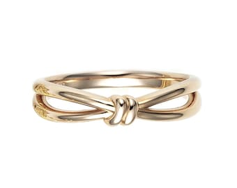 May include: A gold ring with a double-loop design that resembles a bow.