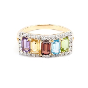 May include: A gold ring with a row of five colorful gemstones set in a diamond halo. The gemstones are purple, yellow, red, blue, and green.