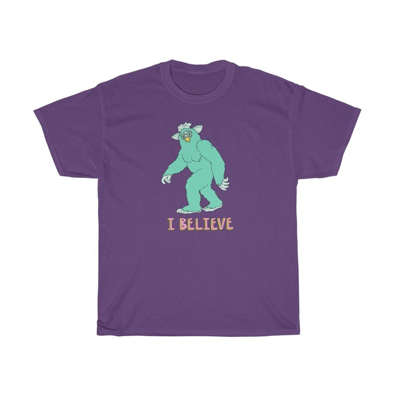 May include: Purple t-shirt with a green monster graphic and the text "I BELIEVE" in pink and blue.