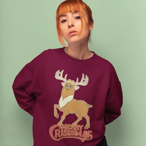 May include: A maroon sweatshirt with a cartoon deer wearing glasses and the text "Merry Crisismas" in a retro font.