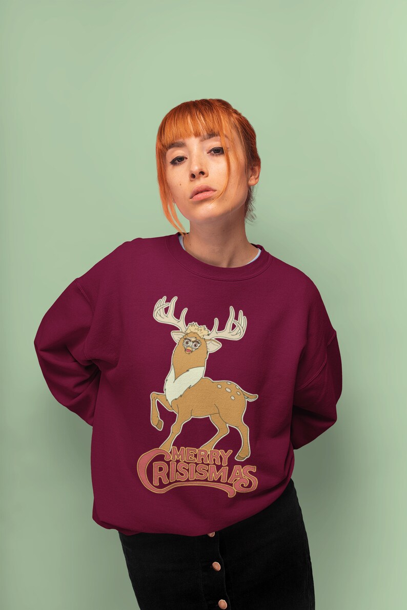 May include: A maroon sweatshirt with a cartoon deer wearing glasses and the text "Merry Crisismas" in a retro font.