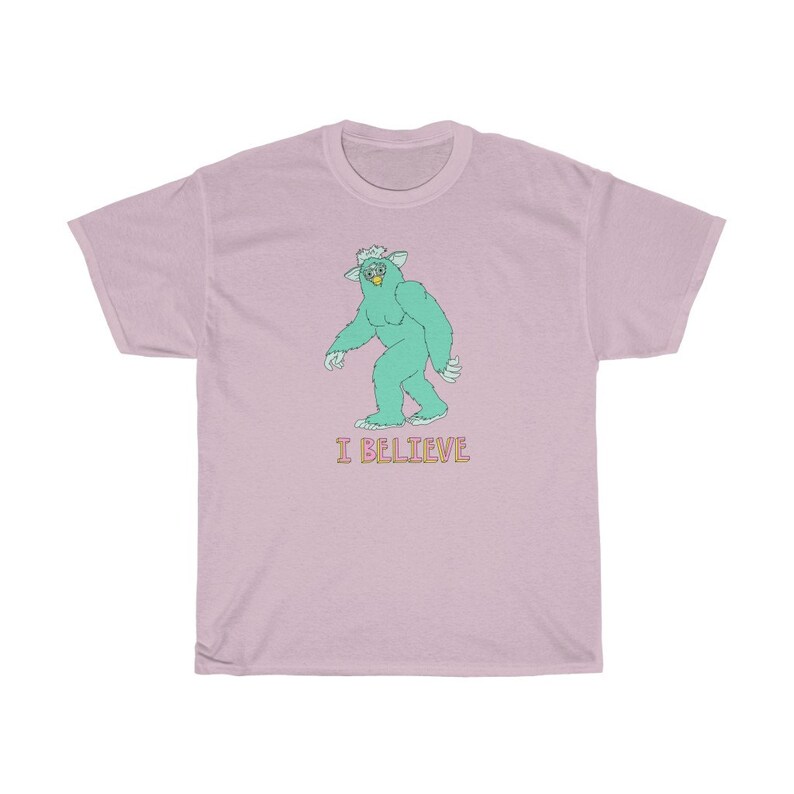 May include: A pink t-shirt with a green monster graphic and the text "I BELIEVE" in pink and yellow.
