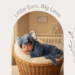 A sleeping baby dressed in a blue elephant costume is nestled in a wicker basket, with a floral design on the right side of the image.