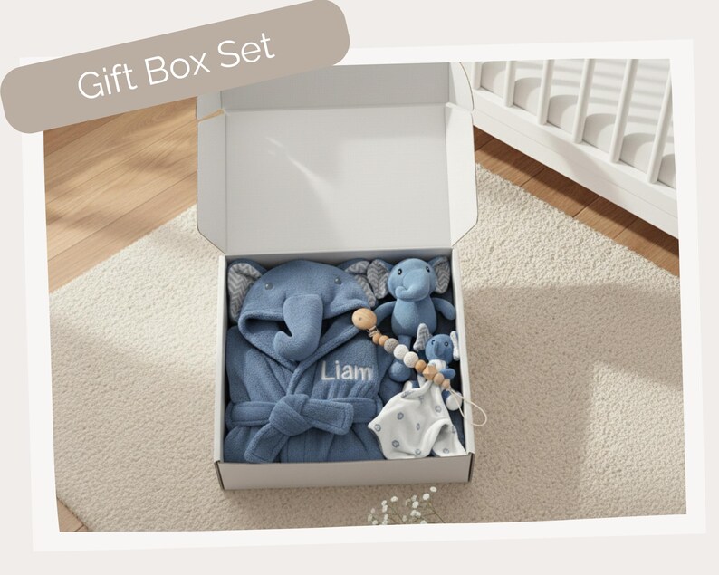 A gift box containing a blue elephant robe, a blue elephant plush toy, and a blue elephant pacifier.