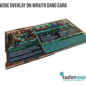 May include: A clear acrylic game card overlay for the game "Cyberpunk Red" featuring the Wraith gang card "Espectros". The card has a green and black color scheme with a graphic of the gang members. The card includes text in Spanish, including the gang name, "Espectros", and the text "Saqueadores".