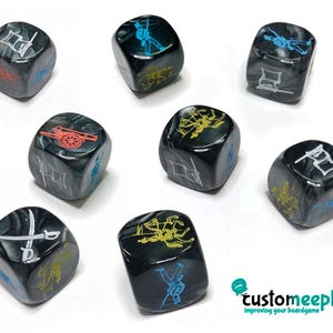 Puede incluir: Una colección de ocho dados de color gris oscuro con ilustraciones blancas, amarillas, rojas y azules. Cada dado presenta diferentes imágenes, incluyendo un cañón, un soldado y espadas cruzadas. Los dados están diseñados para juegos de mesa.