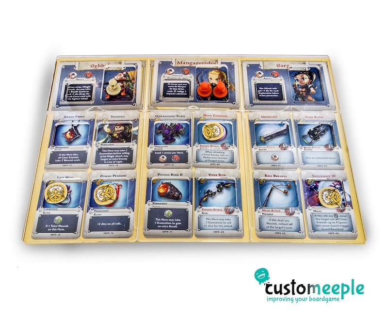 Pu&ograve; includere: Un set di 12 carte da gioco a tema fantasy con illustrazioni di personaggi, armi e oggetti magici. Le carte sono disposte in una griglia su una superficie marrone chiaro. Le carte hanno un bordo dorato e uno sfondo blu.