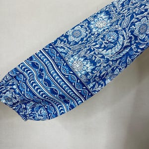May include: Blue and white floral fabric with a geometric pattern. The fabric is soft and flowing, making it perfect for a variety of sewing projects.