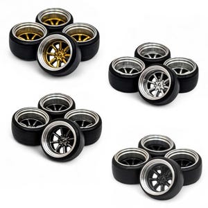May include: Four sets of miniature car wheels. Each set includes four black tires with silver or gold rims. The rims have a multi-spoke design. The wheels are arranged in groups of five against a white background.