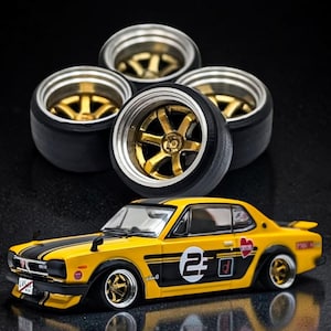 May include: A yellow and black model car with gold-coloured wheels and a set of four spare wheels. The car has the number "23" on the side and black racing stripes. The wheels have a gold-coloured centre.