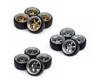May include: A collection of miniature model car wheels. The wheels have black tires with silver or gold rims. The wheels are arranged in groups of four or five, set against a white background.