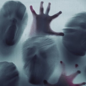 May include: A blurry image of multiple ghostly figures and hands reaching out from behind a frosted glass surface. The figures are translucent and appear to be in a state of distress.