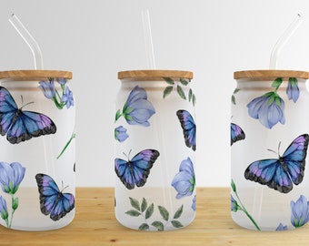May include: Three white tumblers with a blue butterfly and flower pattern. Each tumbler has a wooden lid and a clear drinking straw.