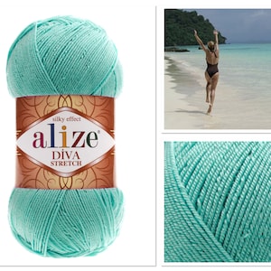 Puede incluir: Una madeja de hilo azul turquesa con el nombre de la marca "alize" y el texto "silky effect Diva Stretch" en la etiqueta.