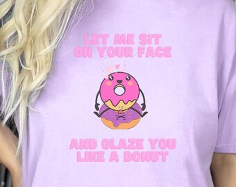 May include: A purple t-shirt with the text "Let me sit on your face and glaze you like a donut" and a cartoon donut with a face.