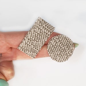 May include: Two woven fabric patches, one rectangular and one round, in a beige and brown pattern.