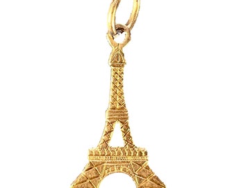 May include: A gold-colored Eiffel Tower charm with a loop at the top for attaching to a necklace or bracelet.