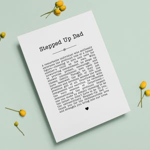 May include: A white card with the text "Stepped Up Dad" and a heartfelt message about fatherhood. The card is decorated with small yellow flowers and a heart symbol, perfect for a gift.