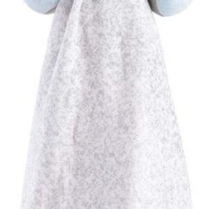 May include: A grey plush dog with blue eyes and a blue and green scarf holds a grey and white blanket with a green clover and a black swirl design.