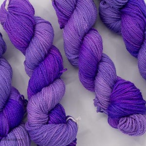 May include: Four skeins of purple and lavender yarn with a gradient color effect.