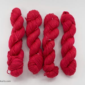 May include: Four skeins of bright red yarn, each wound into a ball shape.