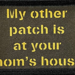 May include: A dark green patch with yellow text that reads "My other patch is at your mom's house".