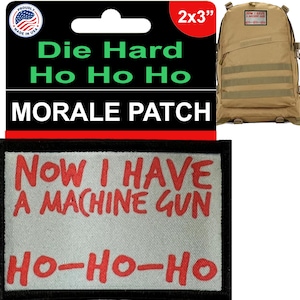 Puede incluir: Un parche de moral blanco con borde negro y texto rojo que dice "NOW I HAVE A MACHINE GUN HO-HO-HO". El parche mide 2 pulgadas por 3 pulgadas.