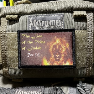 Op de afbeelding: Een bruin patch met zwarte stiksels toont een leeuw met vlammen erachter. Het patch heeft de tekst "The Lion of the Tribe of Judah Rev 5:5" in witte letters.