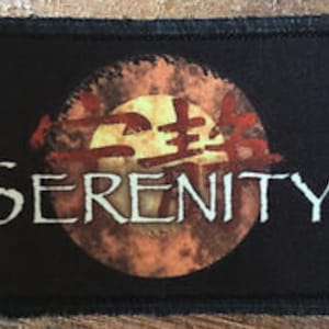 May include: Black fabric patch with a distressed orange and yellow circle containing Chinese characters and the word "SERENITY" in white lettering.