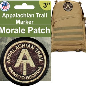 May include: A 3-inch round morale patch with a black border and a white background. The patch features the Appalachian Trail logo, a white A inside a white triangle, with the words "Appalachian Trail" and "Maine to Georgia" in a brown arc around the logo.