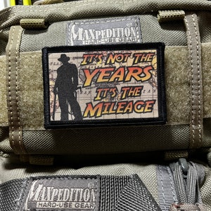 May include: A green Maxpedition Hard-Use Gear bag with a black patch that reads "It's not the years, it's the mileage".