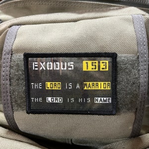 May include: A gray backpack with a black patch that says "EXODUS 15:3 THE LORD IS A WARRIOR THE LORD IS HIS NAME".