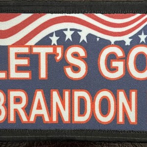 May include: A blue and red American flag patch with white stars and the text "LET'S GO BRANDON!" in white letters with a red outline.